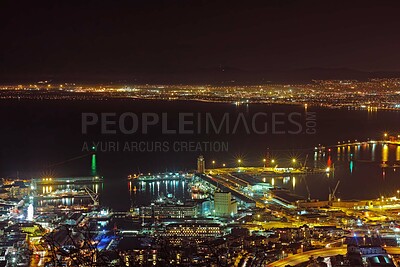 Buy stock photo Ocean, city and night with lights, urban development and aerial perspective of travel destination on island port skyline. Buildings, infrastructure and dark cityscape of coastal town with drone view