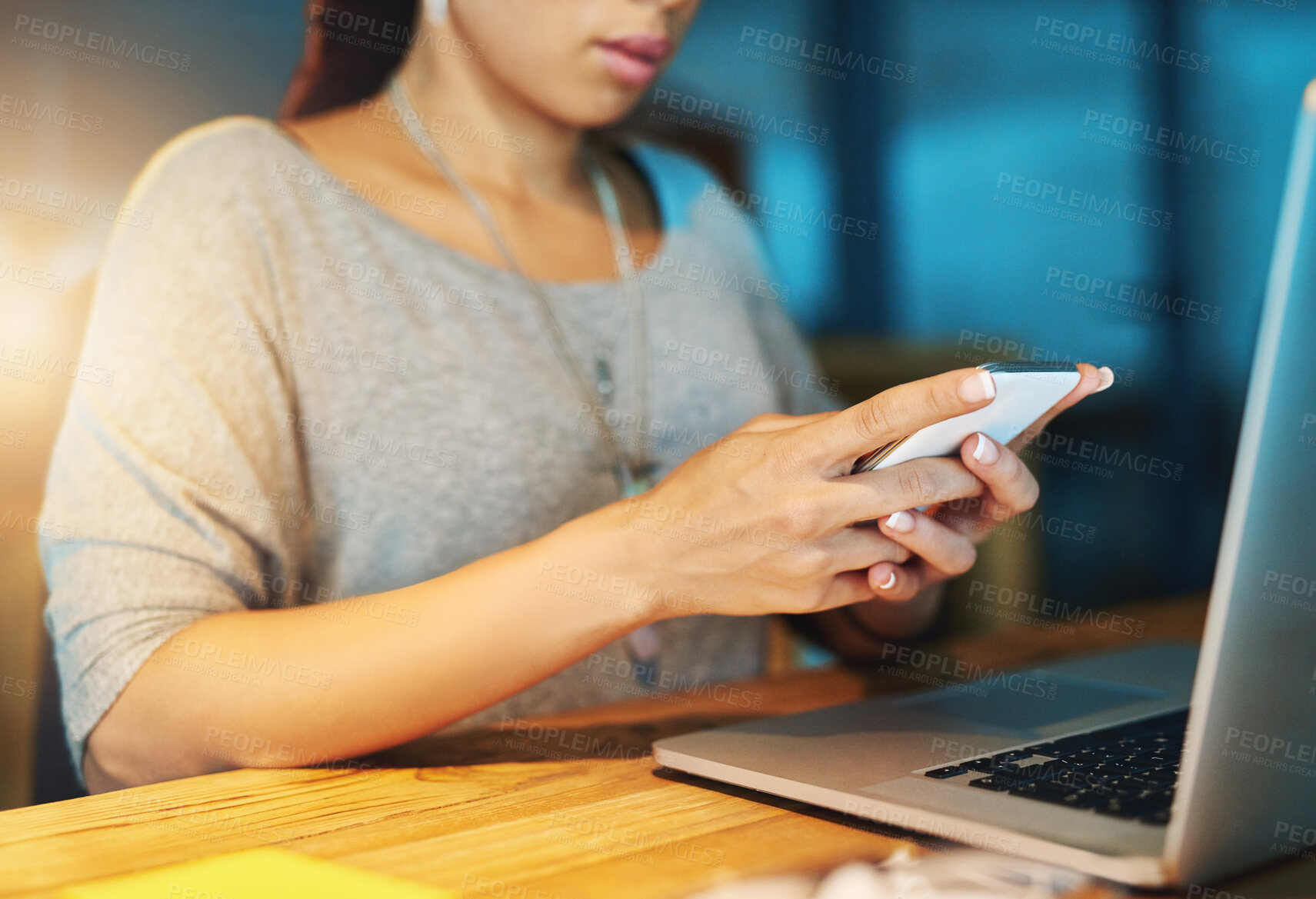 Buy stock photo Businesswoman, hands and phone in office at night with typing text message, reading notification or mobile chat. Professional, employee or tech with laptop at desk for social media scroll at overtime