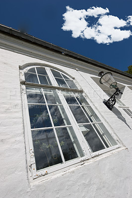 Buy stock photo Vintage hotel, building and window in city for holiday, vacation and low angle outdoor. Glass, home exterior and facade of old architecture for design, construction or real estate property with plant