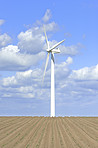 Earth, landscape and sky with wind turbine for renewable energy outdoor to produce electricity. Clouds, nature and recycling with windmill in nature environment for conservation or power supply