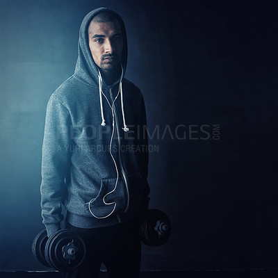 Buy stock photo Man, dumbbells and hoodie in studio portrait for muscle development with mock up space by dark background. Person, bodybuilder and earphones with music for training, workout and exercise in Mexico