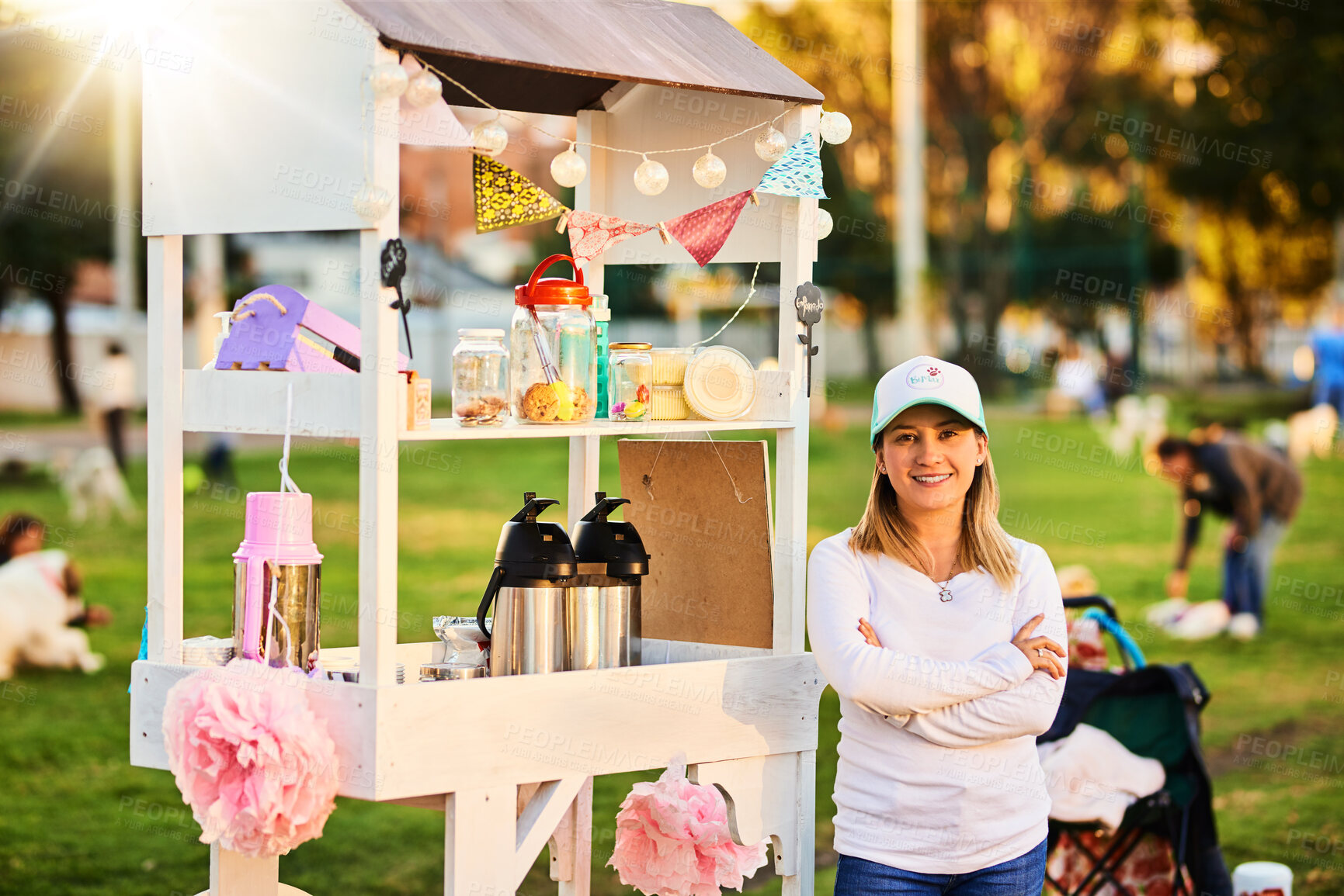 Buy stock photo Woman, portrait and dessert stall outdoor for hospitality industry, cake sale or confectionary of small business. Smile, owner and arms crossed with food cart, bakery choice and selling snack at park