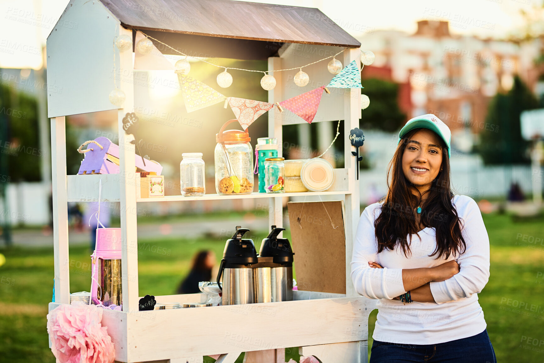 Buy stock photo Woman, portrait and cake stall outdoor for hospitality industry, dessert sale or confectionary of small business. Smile, owner and arms crossed with food cart, bakery choice and selling snack at park