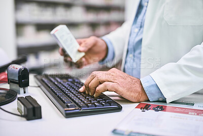 Buy stock photo Shot of a unrecognizable pharmacist typing on a computer keyboard while holding a medication subscription