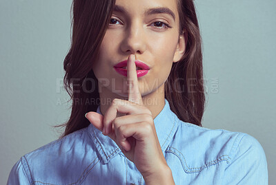 Buy stock photo Woman, portrait or secret with private gossip, confidential tips or beauty tricks on a studio background. Young face, female person or attractive model with finger on lip for silence, mystery or hush