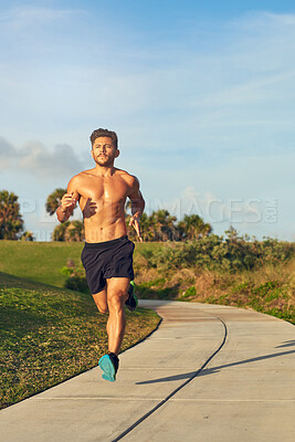 Buy stock photo Fitness, shirtless and man running in park for cardio, challenge and training for marathon in summer. Topless person, serious and muscular athlete with energy for outdoor sport, exercise and workout