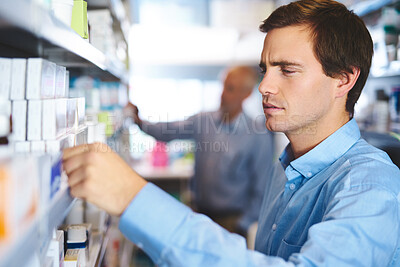 Buy stock photo Man, reading and customer in pharmacy for medicine, shopping and medical product with prescription. Male person, shelf and check label in chemist for health supplements, choice and healthcare pills