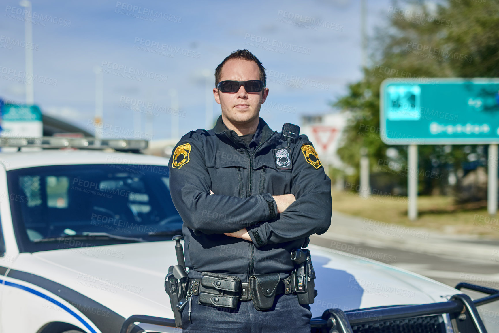 Buy stock photo Man, arms crossed and police officer on duty, outdoor and uniform for responsibility in city. Male person, law enforcement and cop for public service of security, sunglasses and authority in traffic