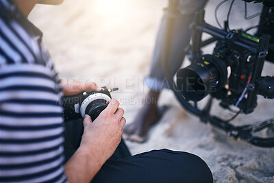 Buy stock photo Filmmaker, hands and check camera for photoshoot results, video analysis or quality control. Production process, person and settings for nature, movie or videography with professional gear on beach