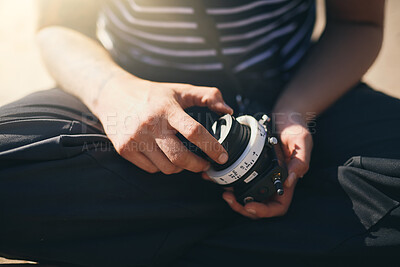 Buy stock photo Hands, photographer and check lens outdoor to prepare for creative film or videography. Cameraman, closeup and professional person with camera, equipment or change gear at beach for movie production