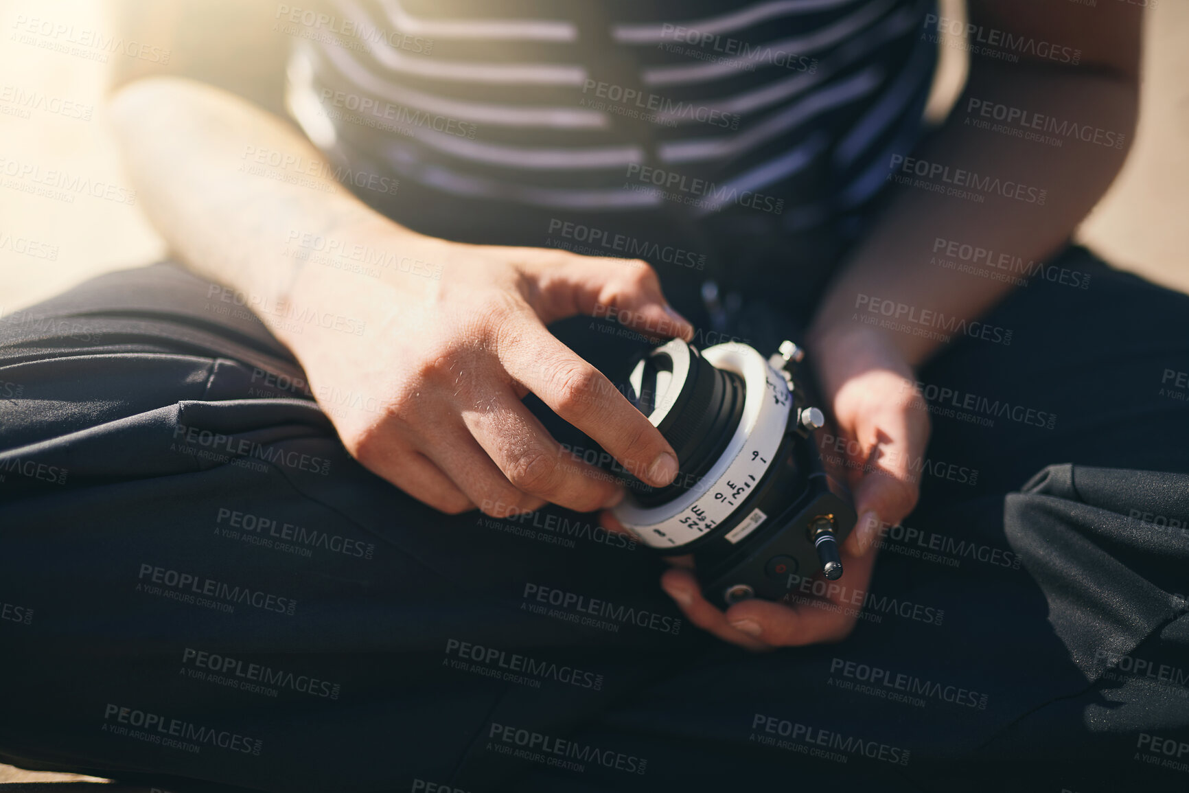 Buy stock photo Hands, photographer and check lens outdoor to prepare for creative film or videography. Cameraman, closeup and professional person with camera, equipment or change gear at beach for movie production