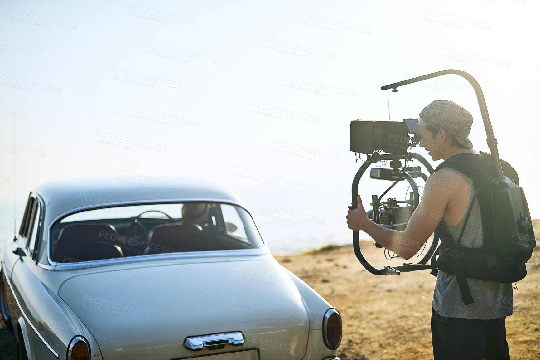 Buy stock photo Filmmaker, camera and vehicle for beach photoshoot, video analysis or travel documentary filming. Production process, person and recording for nature, movie or videography with professional gear