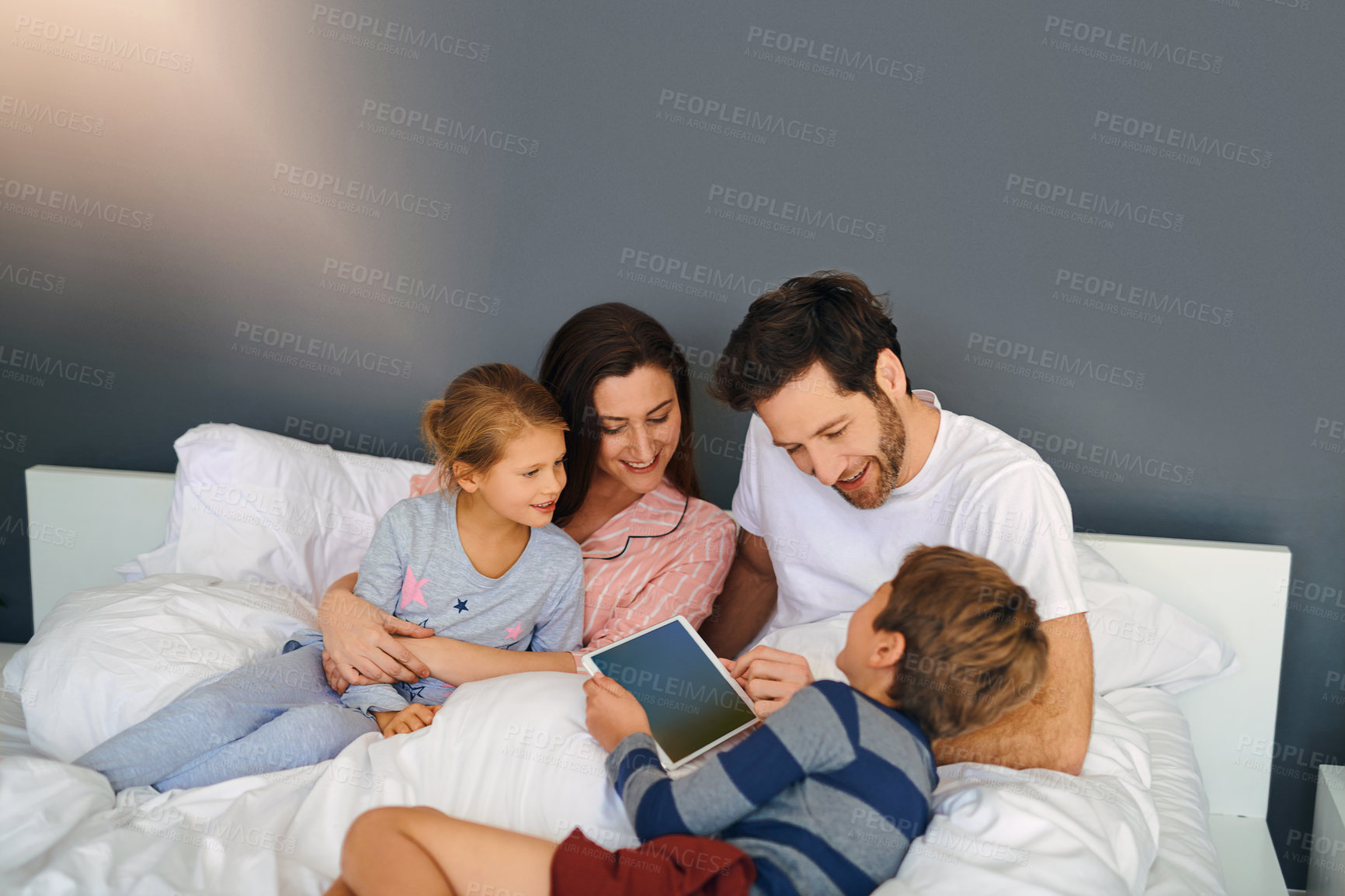Buy stock photo Kids, tablet and family bonding on bed in home, educational games and watching cartoon together. Children, digital app or comfort of parents in bedroom for online video or streaming service in house