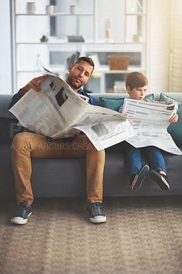 Buy stock photo Father, child and reading a newspaper on sofa in home for article, information or knowledge with bonding. People, man or boy kid with print publication on couch in living room for newsletter or story