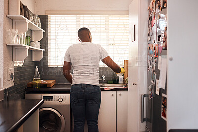 Buy stock photo Rearview shot of a man doing the dishes at home