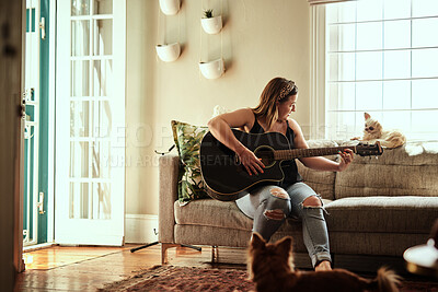 Buy stock photo Woman, home and playing guitar on sofa in living room for rehearsal, practice and song writing. Female person, musician and instrument on couch in lounge at apartment with hobby, skill and talent