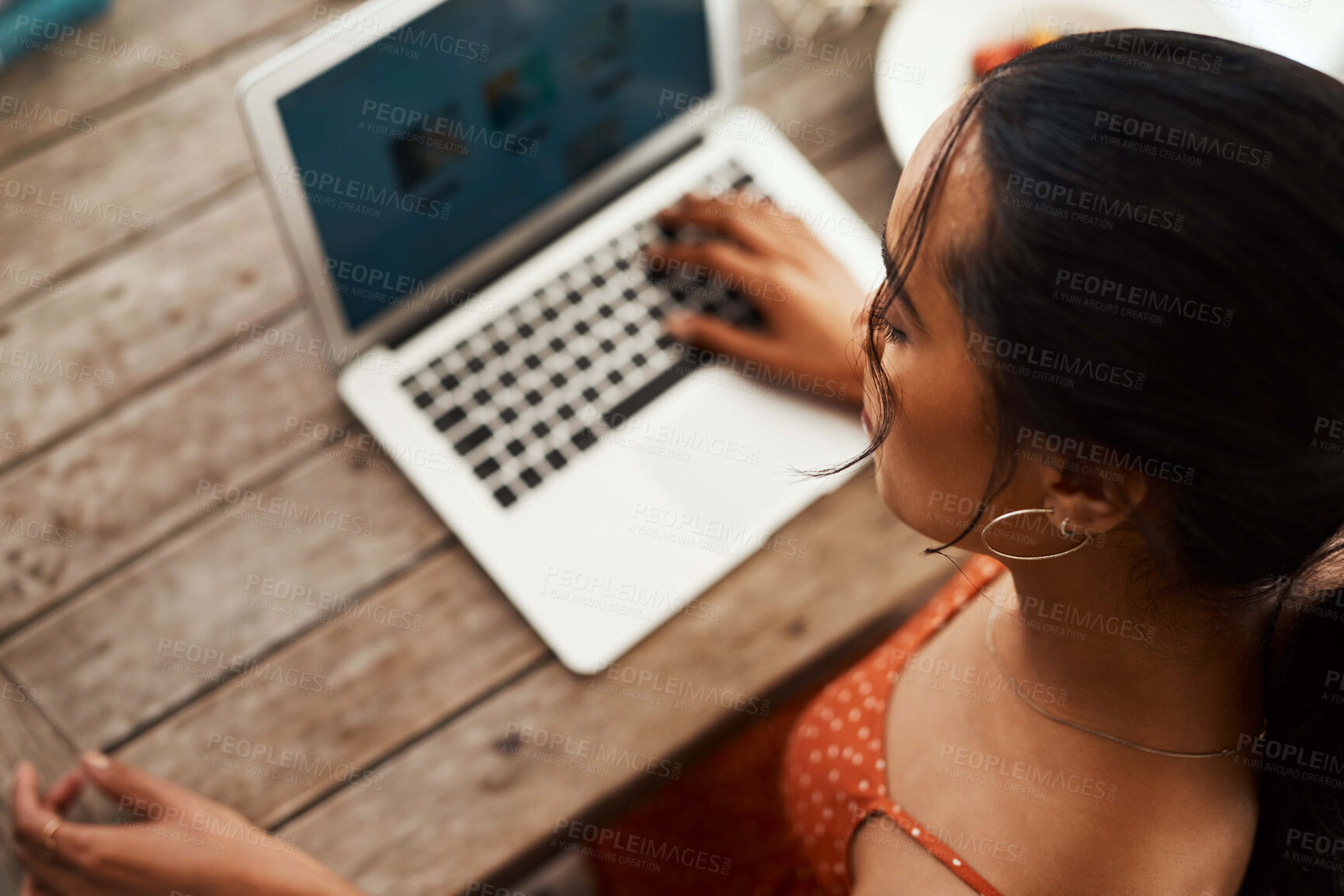 Buy stock photo High angle shot of an unrecognizable businesswoman sitting in her home office and going through her blog