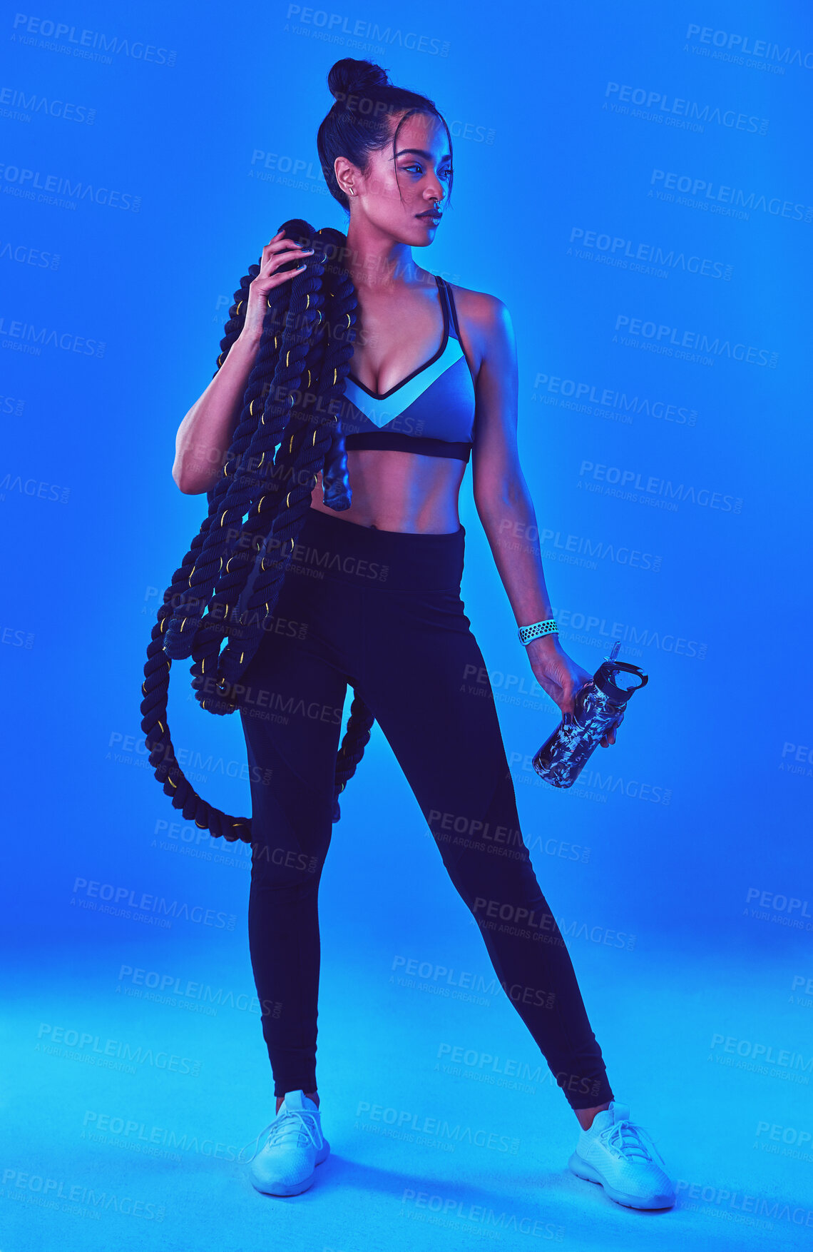 Buy stock photo Fitness, battle rope and woman with water in studio for bodybuilder workout, training and exercise. Personal trainer, gym and person with equipment for health, wellness and muscle on blue background