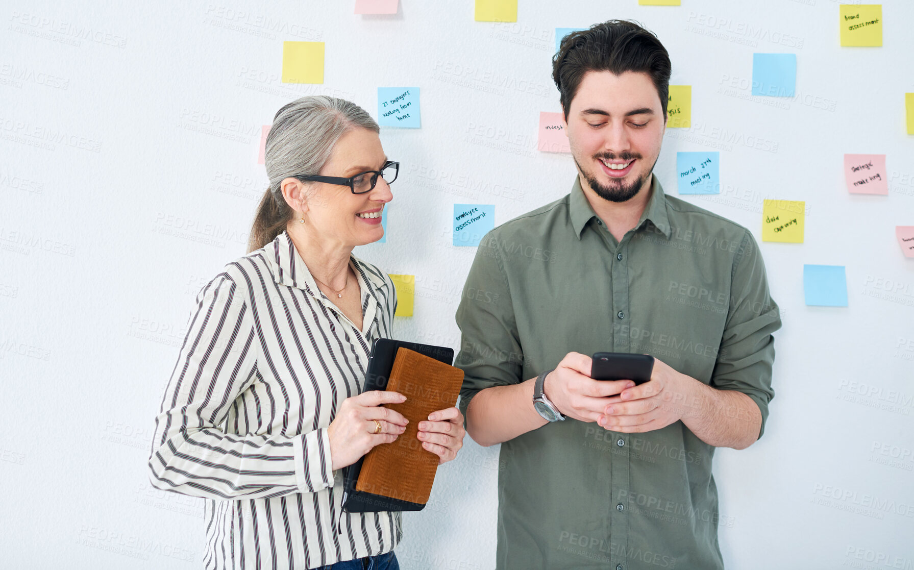 Buy stock photo Phone, meeting and business people in office in discussion for brainstorming, project and agenda. Creative company, mentor and man and woman with sticky notes for teamwork, research and startup