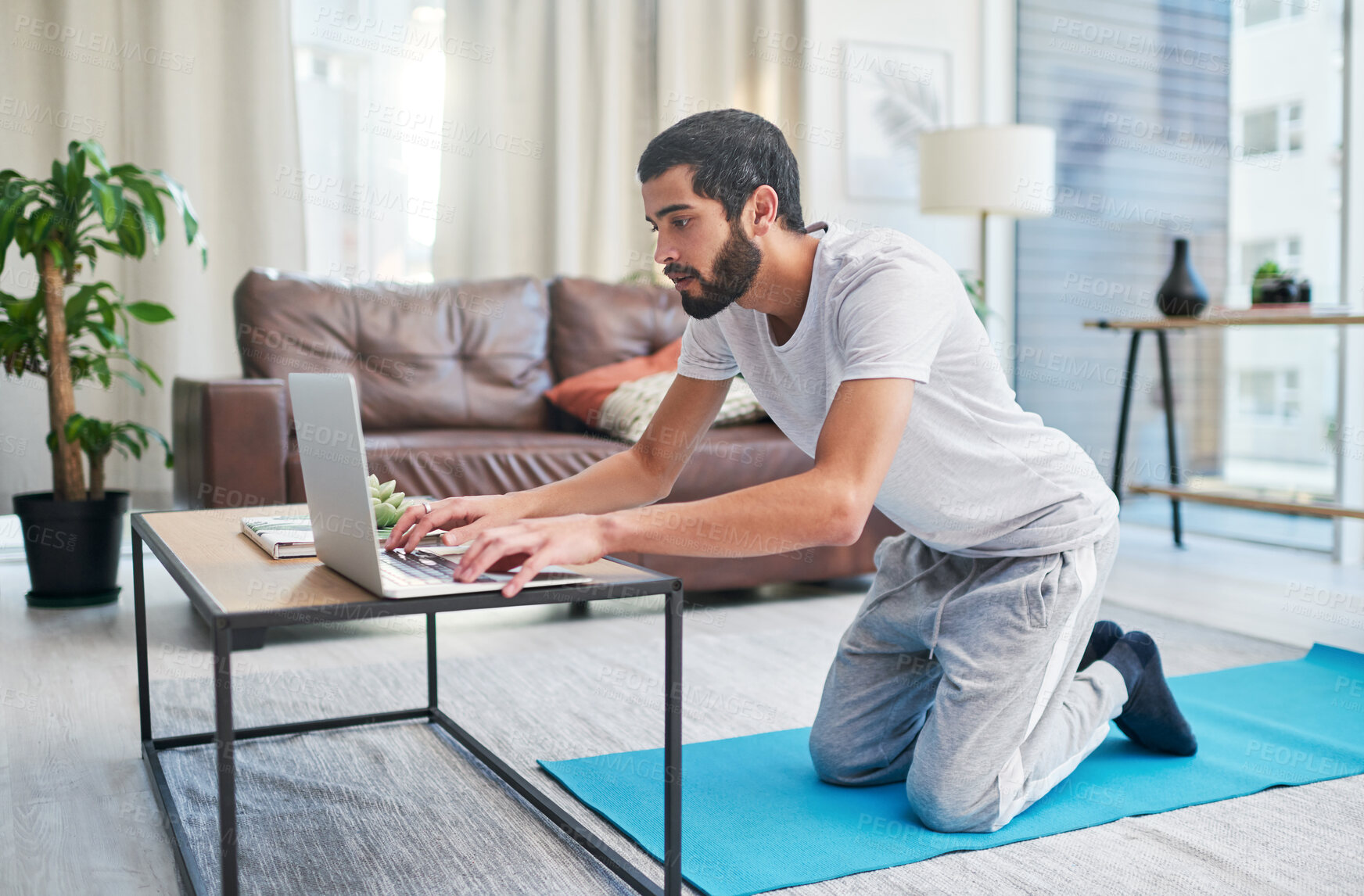 Buy stock photo Getting ready, laptop and yoga with man in living room of home for start of exercise or online class. Computer, log in or streaming with yogi person in apartment for holistic fitness or pilates