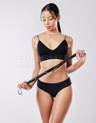 Buy stock photo Studio shot of a woman holding a whip while posing in her underwear