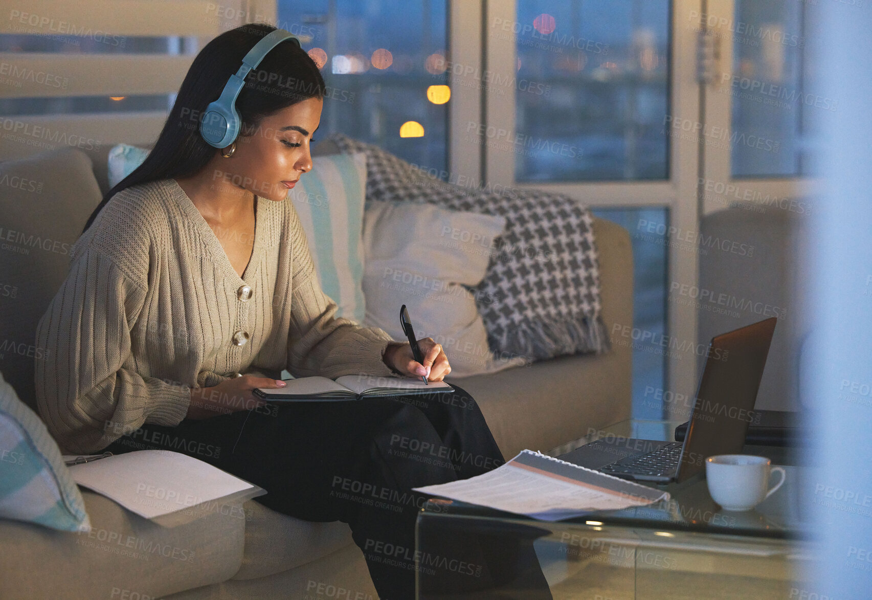 Buy stock photo Laptop, notes and woman on sofa with headphones, studying and virtual university project at night. Elearning education, research and college student with computer, webinar and online course at home