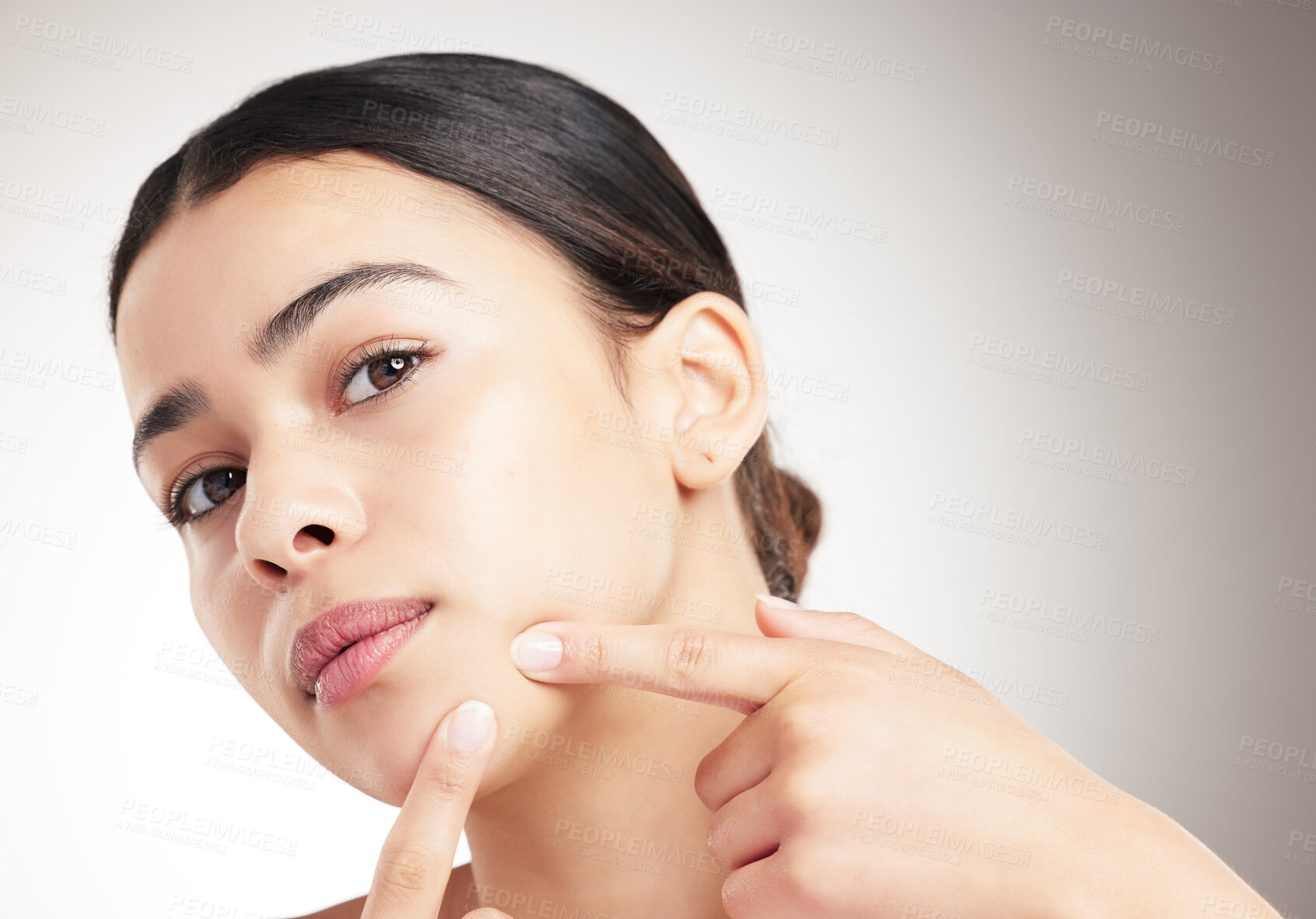 Buy stock photo Portrait, woman and pop pimple in studio for skincare breakout, acne anxiety and dermatology treatment. Girl, press and facial allergy for beauty stress, dry skin and scar disaster on gray background