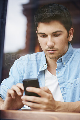 Buy stock photo Man, relax and reading with phone at cafe for dating app, communication and message on platform. Person, serious and scroll with tech at restaurant for profile match, response and online conversation