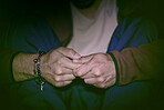 Closeup shot of a man with a mental disorder sitting alone at  feeling paranoid. Mixed race man's hands mentally ill, feeling depressed stressed while suffering a mental breakdown at home