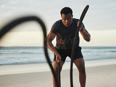 Buy stock photo Fitness, training and black man with rope at beach for strength exercise, endurance and cardio. Serious, male athlete and sunset with arm workout by ocean waves for muscle, challenge and intensity