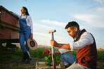 Two farmers working on a field. Young mixed race man and brunette woman working together on their agricultural land. Harvest season always provides the best organic produce