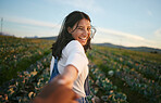 Portrait of a woman in farmer attire holding the hand of her boyfriend while walking in a cabbage field. Unrecognisable person holding hands with a brunette woman on a romantic walk on a farm