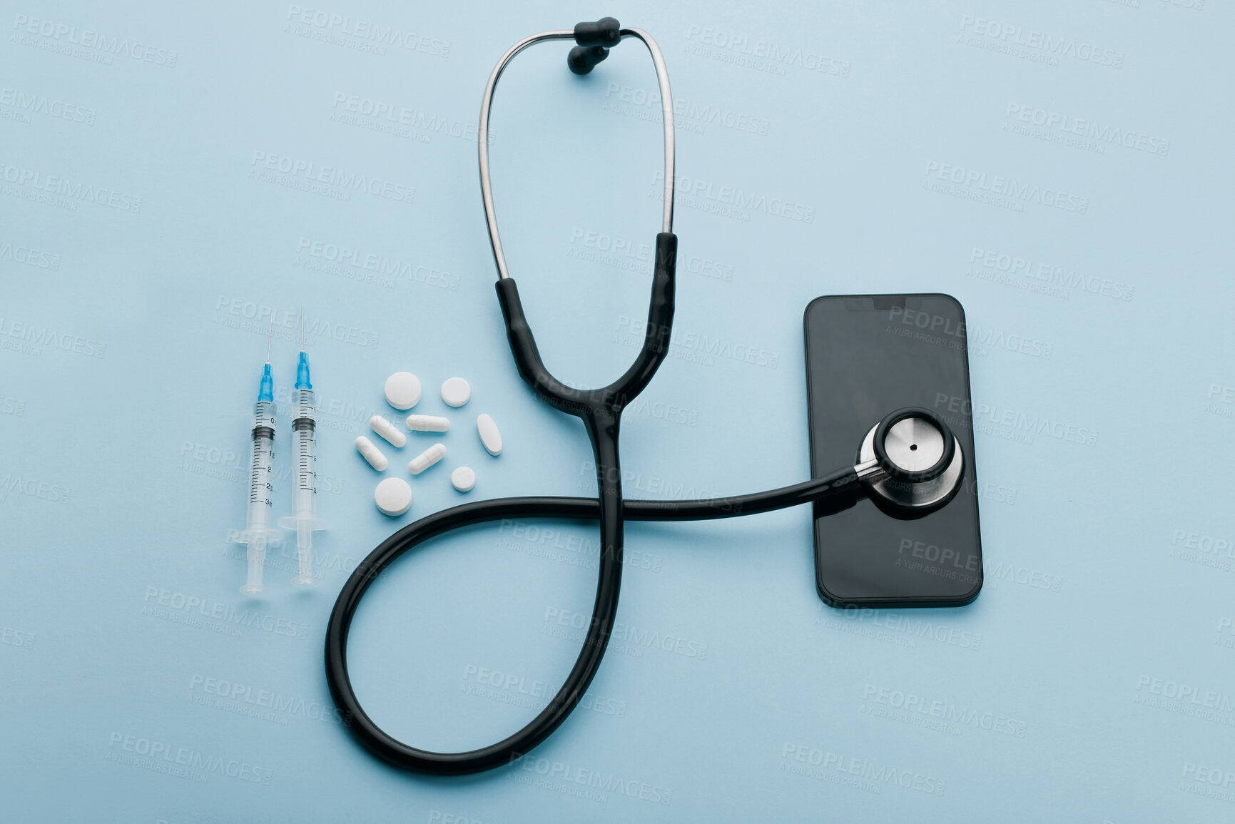 Buy stock photo Stethoscope, phone and pills above with telehealth, healthcare and notification for vaccine. Above, studio and mobile with digital reminder for medical checkup and medication with blue background