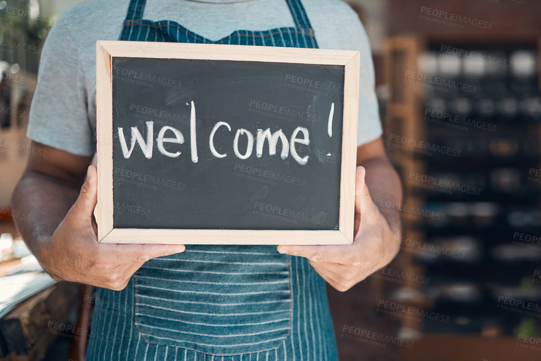 Buy stock photo Waiter, hands and sign with welcome at cafe for hospitality, customer service and ready to start day. Barista, person and chalkboard with message at coffee shop entrance for opening at small business