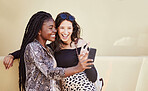 Two influencer friends having fun and showing peace sign while taking selfie outdoors. Multiethnic female friends spending time together in city and taking photos for social media on smartphone