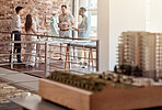 Group of diverse architects discussing plans, blueprints and schematics during a meeting in their office boardroom. Business people brainstorming and planning their upcoming project development