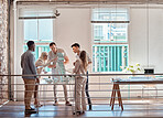 Group of diverse architects discussing plans, blueprints and schematics during a meeting in their office boardroom. Business people brainstorming and planning their upcoming project development