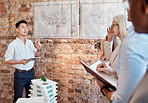 Group of diverse architects discussing plans, blueprints and schematics during a meeting in their office boardroom. Business people brainstorming and planning their upcoming project development