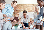 Group of diverse architects discussing plans, blueprints and schematics during a meeting in their office boardroom. Business people brainstorming and planning their upcoming project development