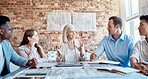 Group of diverse architects discussing plans, blueprints and schematics during a meeting in their office boardroom. Business people brainstorming and planning their upcoming project development