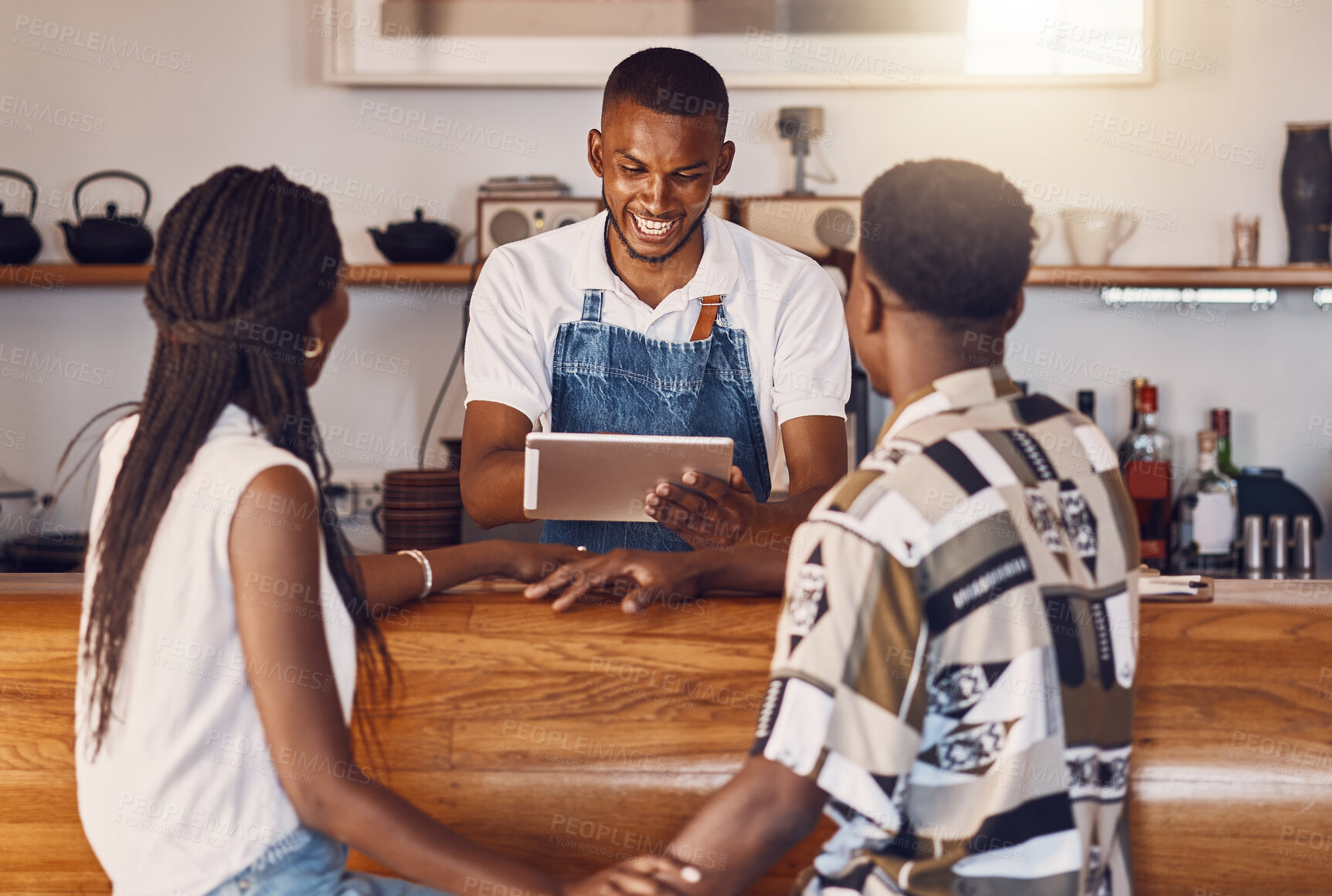 Buy stock photo Hospitality, service and technology with restaurant worker  taking orders on a digital tablet, smiling and talking. Young employee manage customer payment on an online app, paying using the internet