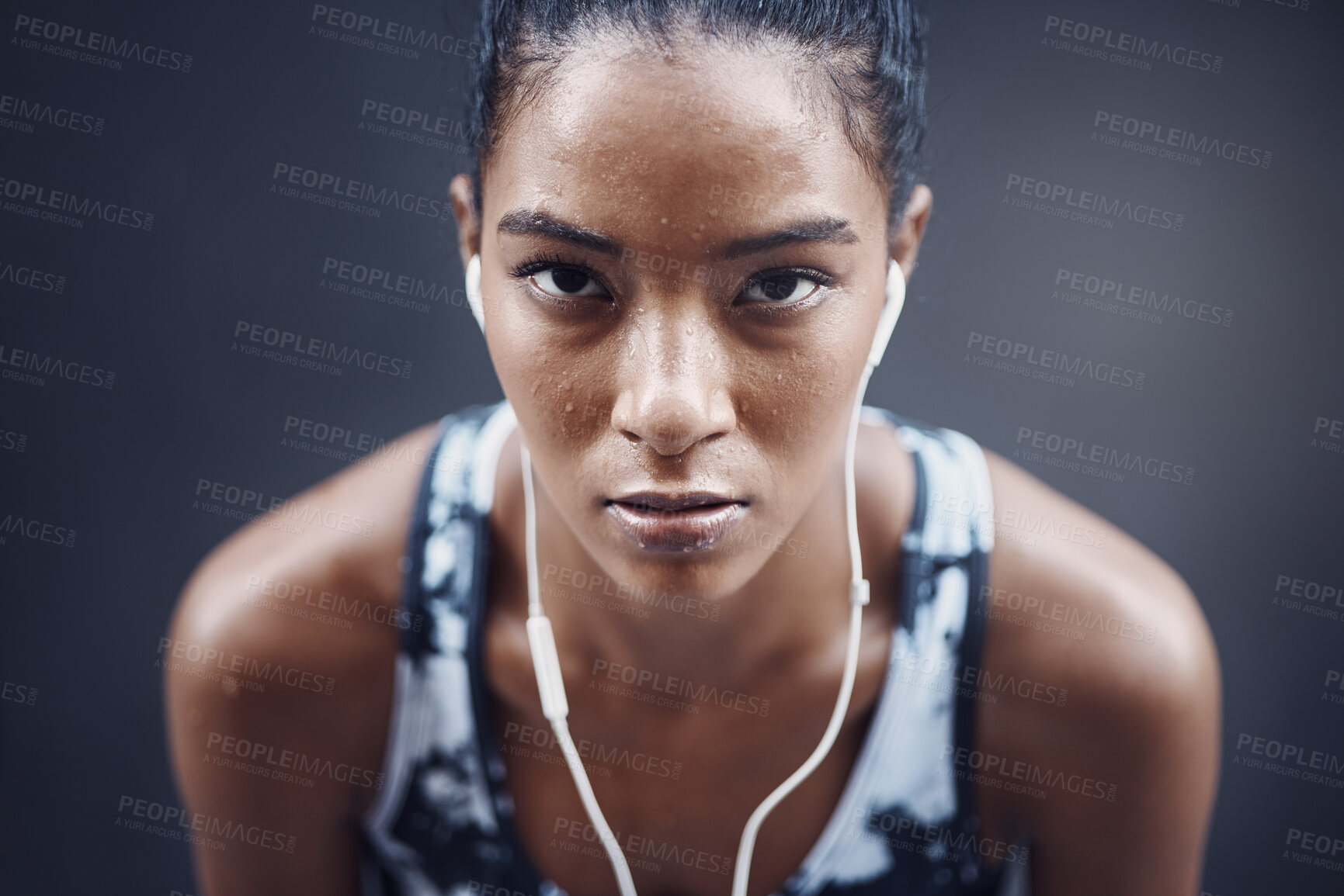 Buy stock photo Woman, portrait and music break on run, outdoor and athlete fatigue with sweat by gray background. Female person, exhausted and earphones for listening to song, tired and cardio challenge with audio