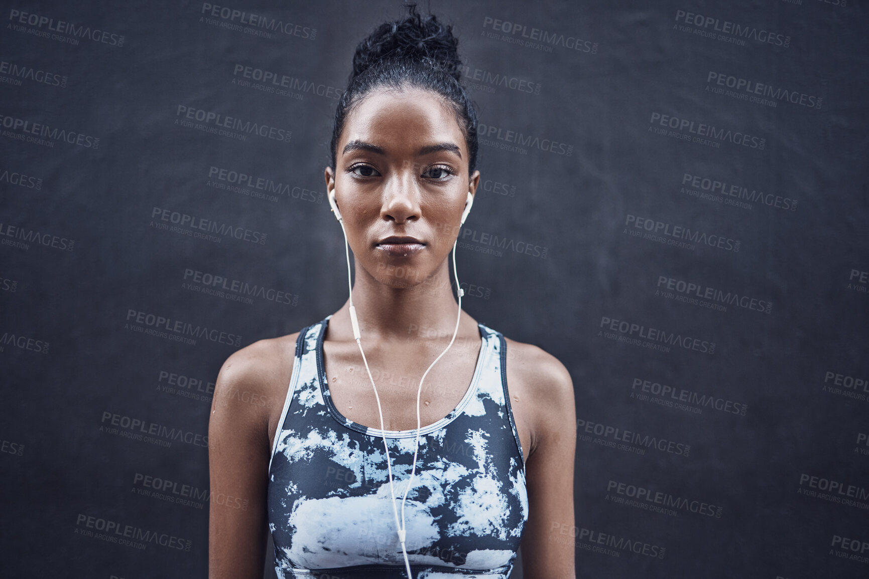 Buy stock photo Woman, portrait and song break on run, outdoor and athlete fatigue with sweat by gray background. Female person, exhausted and earphones for listening to radio, tired and cardio challenge with audio