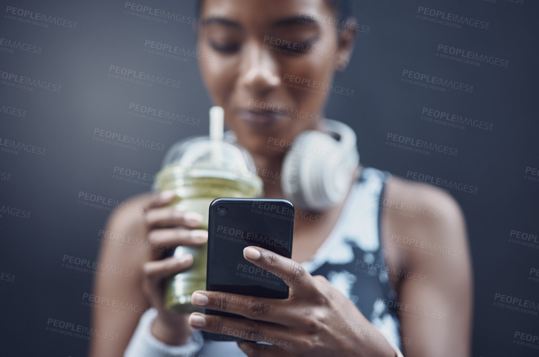 Buy stock photo Hands, fitness and phone in city with person, runner and smoothie for nutrition, detox or wellness by wall. Woman, smartphone and green juice for hydration, diet and training with break in Costa Rica