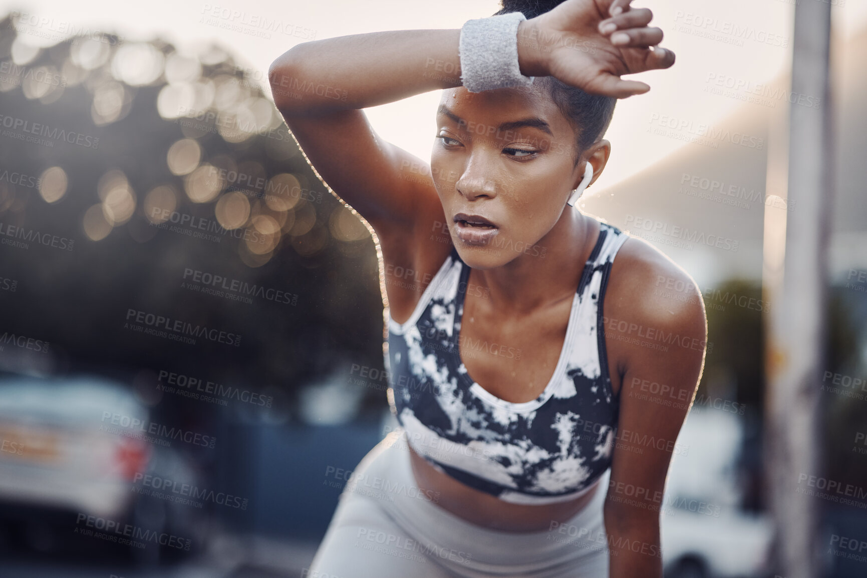 Buy stock photo Woman, runner and tired with earphones in city at sunset with sweat, breathe and burnout with music in street. Girl, break and audio streaming for workout, fitness and fatigue on road in Costa Rica