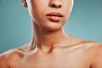 Closeup view of a mixed race woman posing against a green background. Female showing her healthy smooth soft skin in a studio