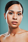 Portrait of a young beautiful mixed race woman with smooth soft skin posing against a green studio background. Attractive Hispanic female with stylish makeup posing in studio