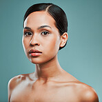 Portrait of a young beautiful mixed race woman with smooth soft skin posing against a green studio background. Attractive Hispanic female with stylish makeup posing in studio