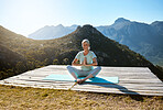 Full length of a senior woman meditating in nature, doing yoga exercise with mountain view in the background. Living a healthy and active lifestyle in retirement