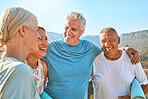 Group of diverse senior friends talking and standing together after doing yoga together in nature. Smiling retirees living active and healthy lifestyles